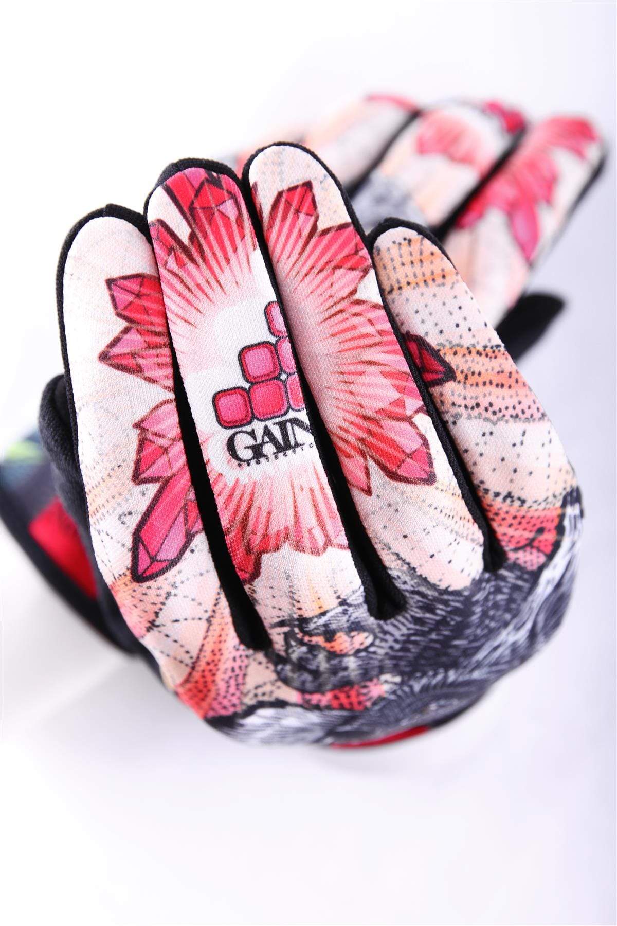 The GAIN Protection Resistance Skate Gloves - Dropbear showcase a vibrant and intricate geometric and floral design in shades of red, pink, and black. Crafted with ARMORTEX fabric for enhanced durability, the gloves feature the word "GAIA" elegantly displayed on their hexagonal pattern on the back. They're an ideal choice for adding a stylish touch against a plain white backdrop.