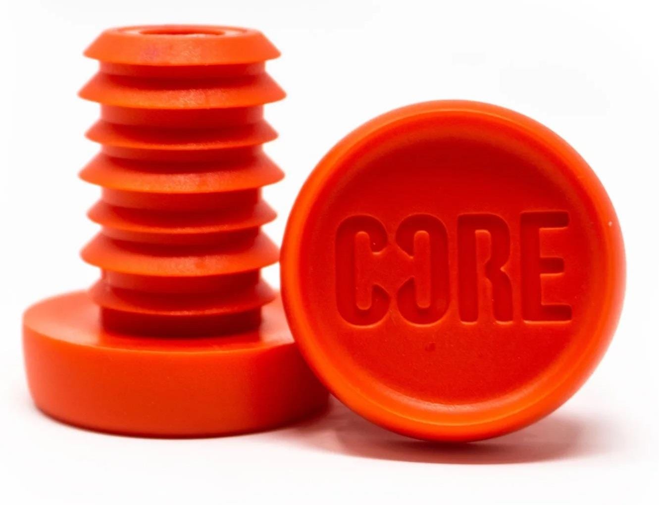 The image displays two vibrant red objects made of aluminum. One has a ridged plug design, while the other is a flat disc with "CORE Aluminium Scooter Bar Ends" embossed on it. They are set against a white background, emphasizing their bold color and sleek design by CORE.