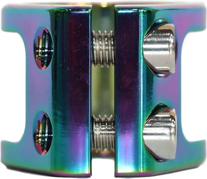 Introducing the JP Scooters Ninja Pro Scooter Double Clamp in Neochrome Oil Slick: This striking clamp by JP is designed for stunt scooters and features a cylindrical shape with open sides, making it ideal for oversized bars. Its iridescent surface reflects a vibrant spectrum from blue to purple and green, accented by two visible bolts.