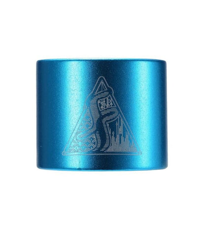 A teal cylindrical object from Fasen that features an engraved design with a stylized snake inside a triangle, resembling the sleek lines of the Fasen 2 Bolt Oversized Stunt Scooter Clamp. The design is intricately patterned and includes a cityscape at the base of the triangle.