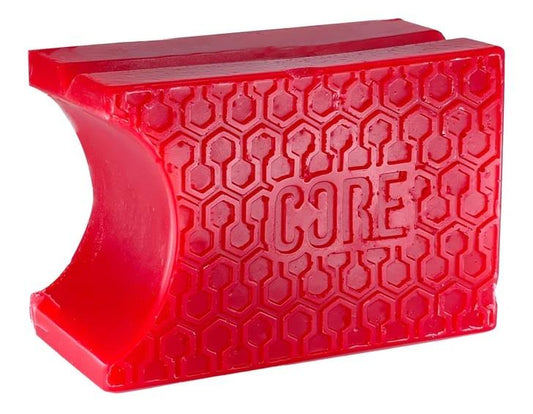 A red, rectangular rubber grip with a honeycomb pattern, featuring the word "CORE" embossed centrally, offers excellent hold enhancement for tools or sports gear. This innovative grip includes pre-grooved shapes similar to those found on CORE Epic Skate Wax - Cherry Red by CORE for superior performance.