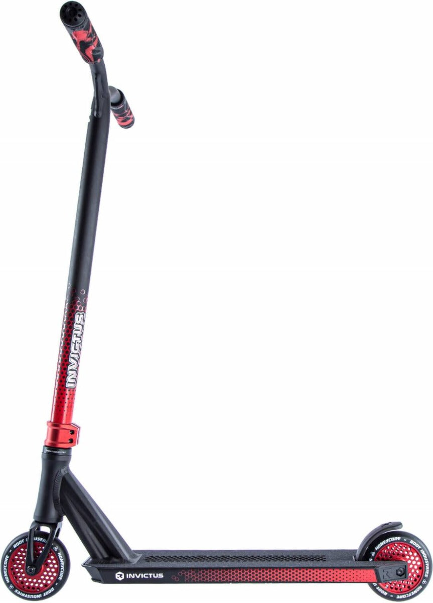 Here's a side view of the Root Industries Invictus 2 Complete Stunt Scooter in Black and Red, showcasing its sleek design. The scooter features red grips on the handlebar and a deck adorned with a black pattern and "Invictus" near the rear wheel. It rides smoothly on stylish Honeycore wheels highlighted with striking red accents.