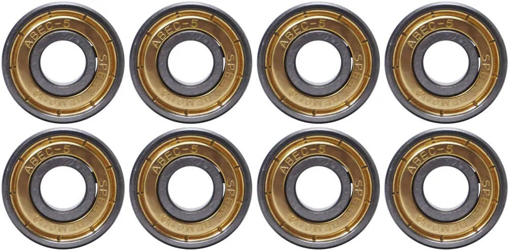 A photo displaying eight Speed Demons ABEC 5 Hot Shot skateboard bearings, arranged in two rows of four. Each bearing showcases a metallic outer ring inscribed with "ABEC-5" and other markings, ideal for any skateboard setup. The inner ring highlights a dark central hole.