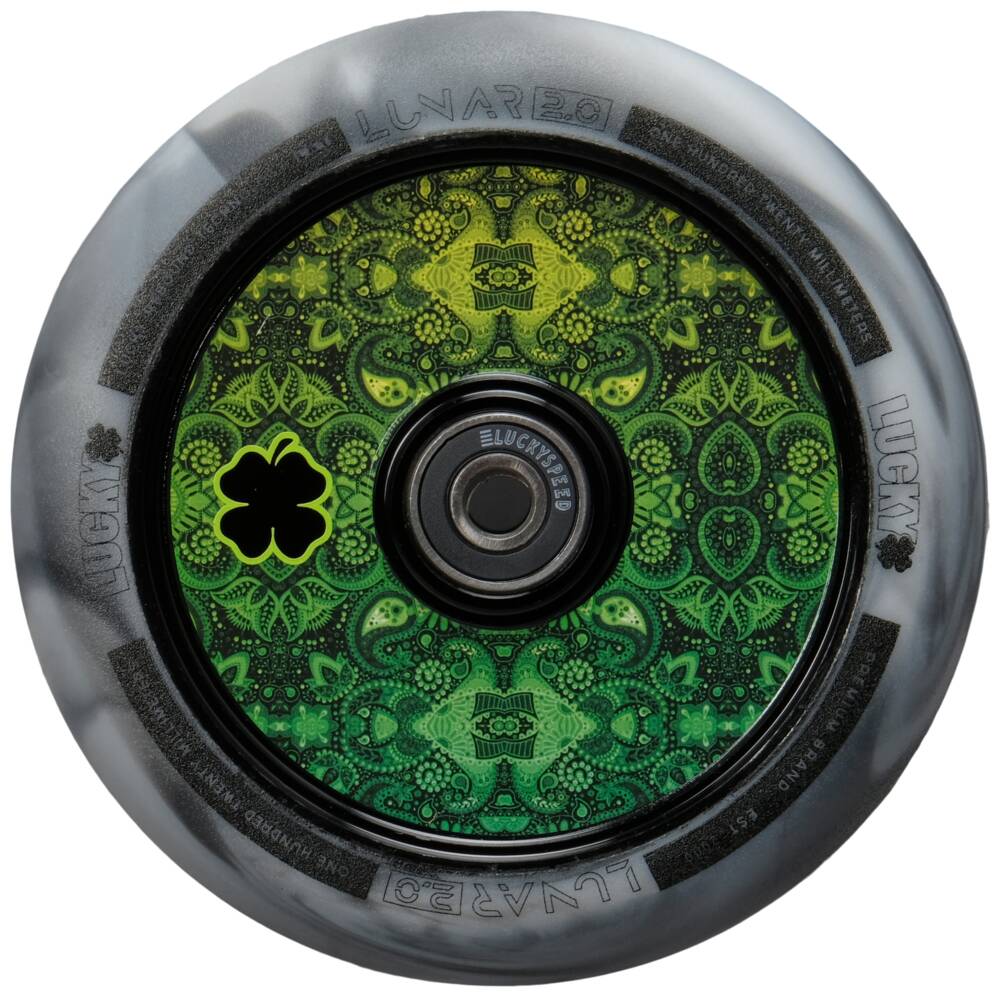 A detailed close-up of the Lucky Lunar 100mm Stunt Scooter Wheel - Recoil highlights its intricate green and black patterns at the core, featuring a decorative four-leaf clover symbol. This 100mm wheel from Lucky integrates Lucky Rebound Technology, ensuring smooth rides with its dark gray outer edge.