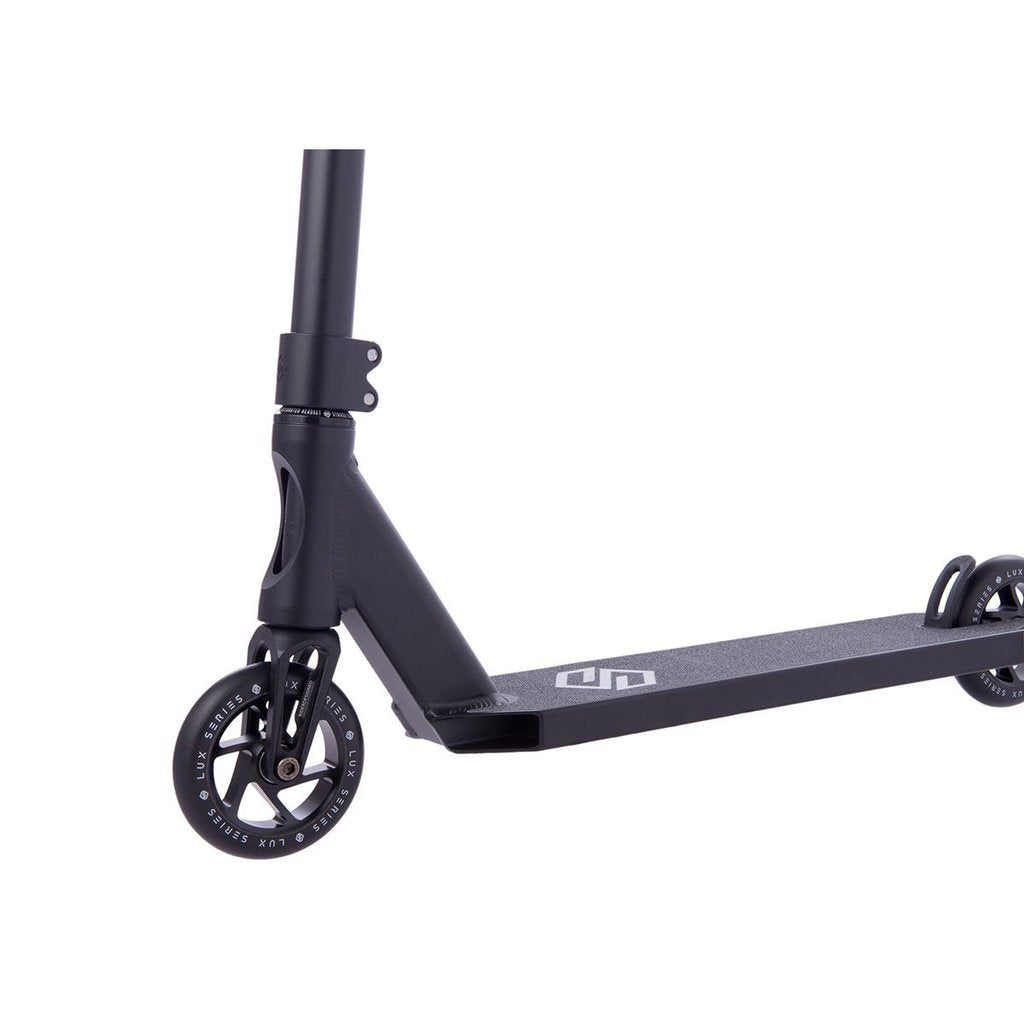 Introducing the Striker Lux Pro Complete Stunt Scooter in Black by Striker, featuring a sturdy yet lightweight aluminum frame, two wheels with white accents, and a textured deck. The sleekly designed handlebars enhance its elegant appearance as it is artfully positioned on a white background.