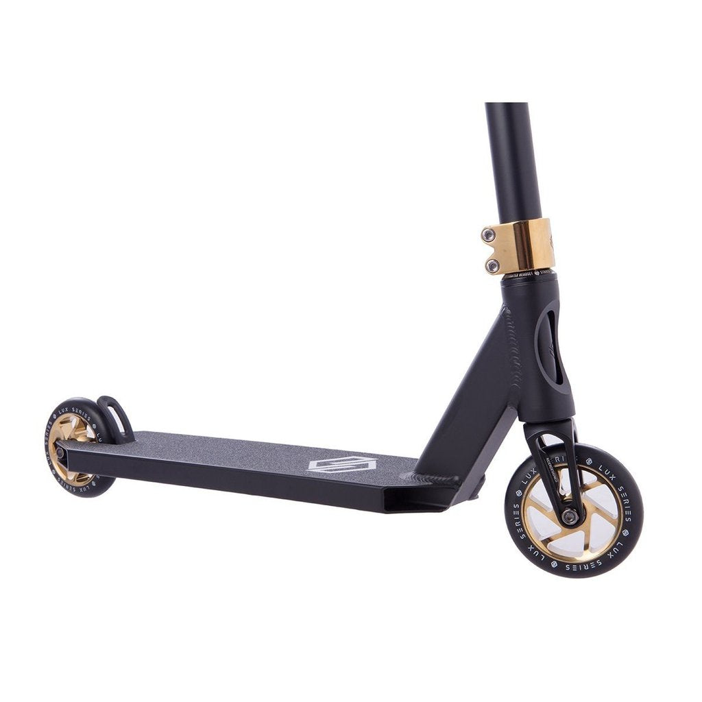 The Striker Lux Pro Complete Stunt Scooter - Gold Chrome, by Striker, is an elegantly designed lightweight scooter in striking black with gold accents. It features a sturdy aluminum frame, two wheels, and comfortable handlebar grips for smooth and stylish rides.