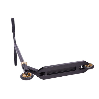 A black aluminum scooter rests on its side against a white backdrop, featuring wheels accented in gold chrome and smooth black handlebars. Its rectangular deck emphasizes the minimalist design of the lightweight Striker Lux Pro Complete Stunt Scooter.