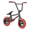 The Invert Supreme Havoc Mini BMX Bike features a sleek black frame complemented by vibrant red marble tires and matching handle grips, offering a minimalist design that makes it perfect for action sports enthusiasts looking for a stylish ride.