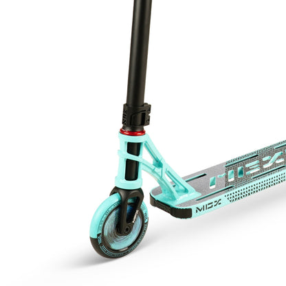 Close-up of the Madd Gear MGP MGX P2 Pro Complete Stunt Scooter - Taze's front wheel and deck. The aqua and black wheel features a sturdy fork, while the deck showcases a grey and black design with "MGP" clearly visible, indicating its MGX P2 Pro lineage.