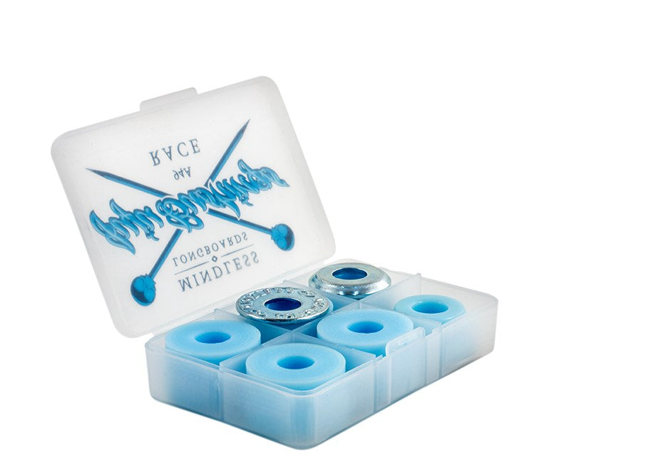 A transparent plastic case featuring blue wheels and silver bearings, specifically designed for skateboards, includes Mojo Urethane and showcases blue text and graphics on the lid. This product is named Mindless Juju Race Blue Longboard Bushings - 94A by the brand Mindless.