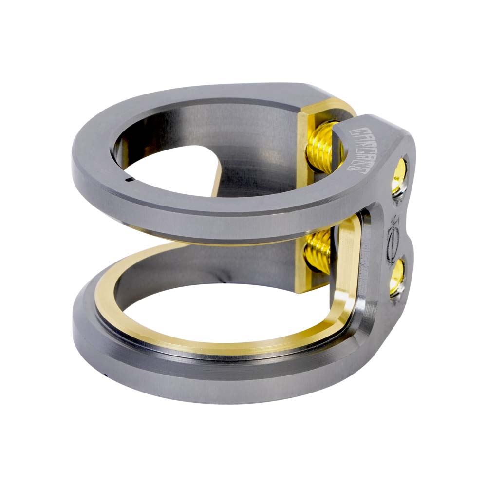 A titanium scooter clamp with a sleek design, featuring a two-bolt mechanism for secure attachment, crafted from durable materials. It boasts a matte titanium finish with gold accents, similar to the Oath Carcass 2 Bolt Oversized Stunt Scooter Clamp by Oath.