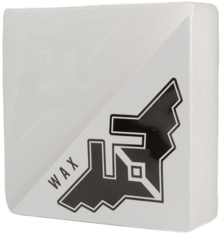 The Fracture Wings Skateboard Wax - White is a large bar of white wax featuring a geometric black and white Fracture logo on the lower right corner, perfect for tackling the toughest ledges and rails. The word "WAX" is emblazoned along the side, making it ideal for skateboarders who use this product.