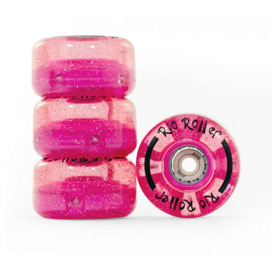 The image features four pink glitter Rio Roller Light Up quad skate wheels, each measuring 58mm by 32mm. The translucent wheels display white "Rio Roller" lettering and a sparkly finish. Three are stacked on the left, while one stands upright on the right, revealing its bearing. The glittery design exudes vibrant energy with its light-up effect.