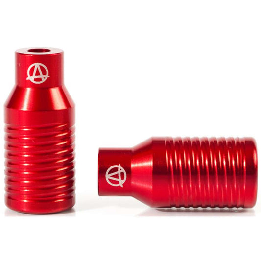 A pair of Apex Bowie Aluminium Stunt Scooter Pegs in red, featuring a cylindrical shape with ribbed textures and a white logo on top. One peg is positioned upright while the other rests horizontally, highlighting their robust yet lightweight design.