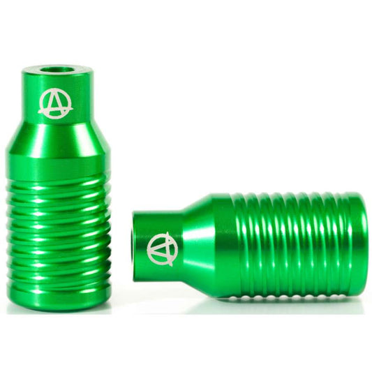 Two gleaming, lightweight anodized metal pegs with ribbed designs and a logo on top. Proudly part of the Apex Bowie Aluminium Stunt Scooter Pegs in Green, one stands upright while the other lies horizontally beside it, showcasing their durable texture and cylindrical shape.