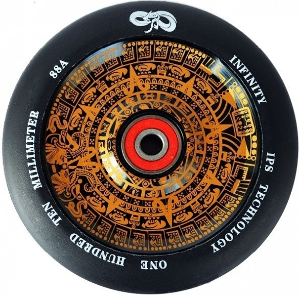 Close-up of a gold stunt scooter wheel highlighting intricate orange Aztec-like designs. The wheel is inscribed with the text: "INFINITY IPS TECHNOLOGY 110 MILLIMETER 88A ONE HUNDRED TEN." A red, semi-hollowcore center showcases ABEC 9 bearings for smooth performance.