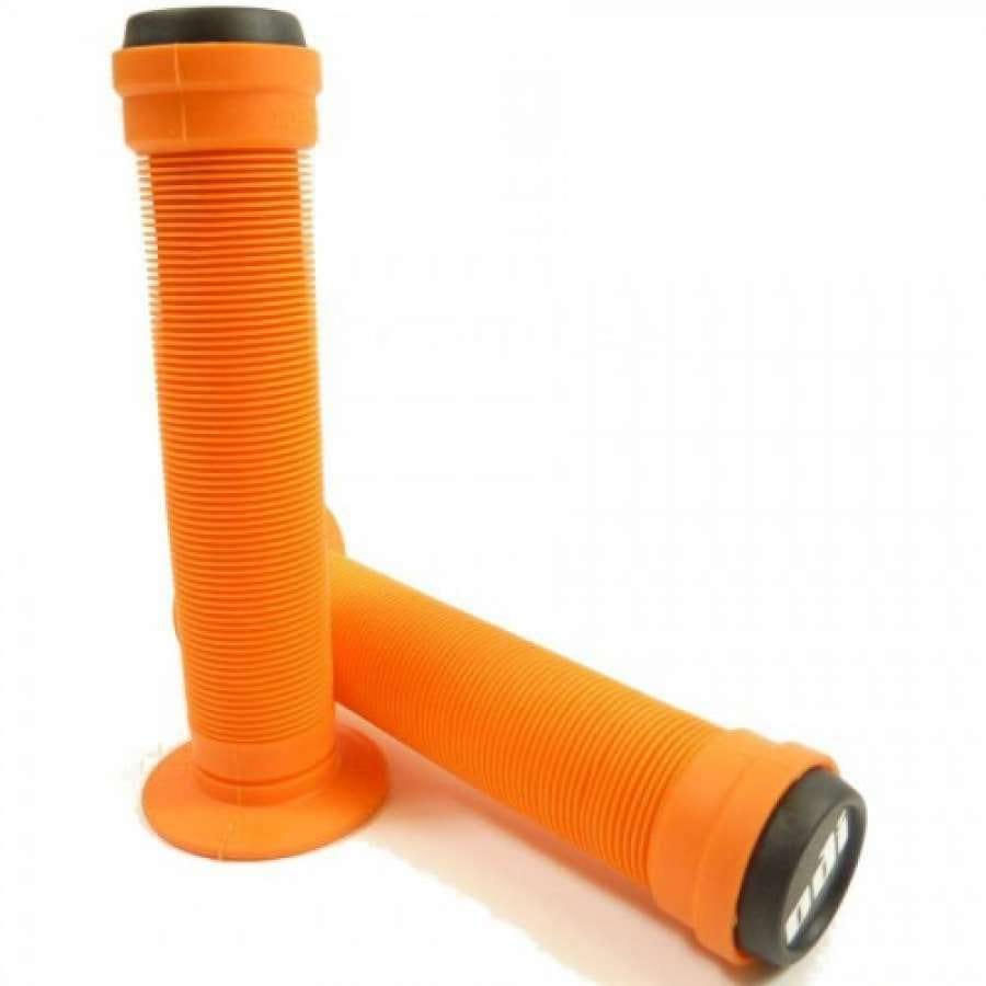 Two ODI Longneck ST Orange Stunt Scooter Grips, each measuring 143mm, are showcased on a white background. One grip stands upright while the other leans against it, both highlighting their ribbed texture made from Krayton rubber and complemented by black resin thug bar ends for a stylish finish.