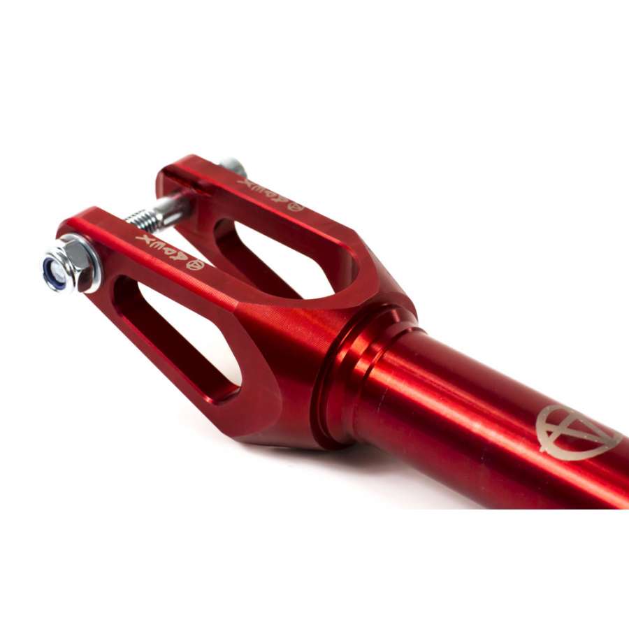 A detailed view of the Apex Quantum SCS/HIC Stunt Scooter Forks in red, showcasing its metal construction with cutouts and a glossy finish. This durable fork upgrade from Apex is engineered to attach to a scooter's front wheel, featuring a bolt and nut assembly at the top.