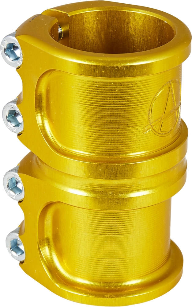 A close-up image of a gold, CNC-machined aluminum clamp from the Apex brand showcases its two-section design with four screws. The smooth, cylindrical shape features engraved lines and strongly resembles the Apex Lite 4 Bolt Oversized SCS Stunt Scooter Clamp, engineered for securely fastening tubular objects.