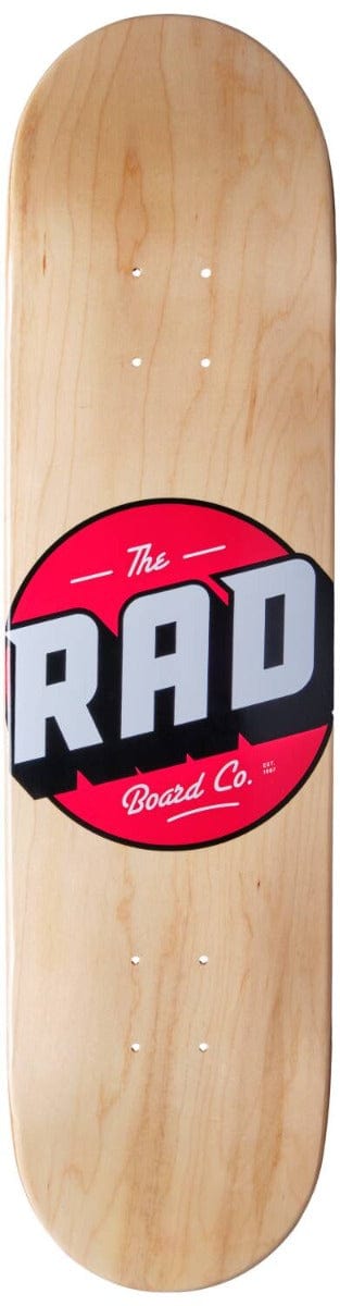 The RAD Solid Logo Wood Skateboard Deck, measuring 8.25" x 32", is constructed from durable 7-Ply Hard Rock Maple and showcases a natural wood finish complemented by a striking design. Ideal for beginners, the deck features a prominent red circle with "RAD" in bold white letters, along with "The Board Co." beneath it. Pre-drilled central holes are included for easy attachment of skateboard trucks.