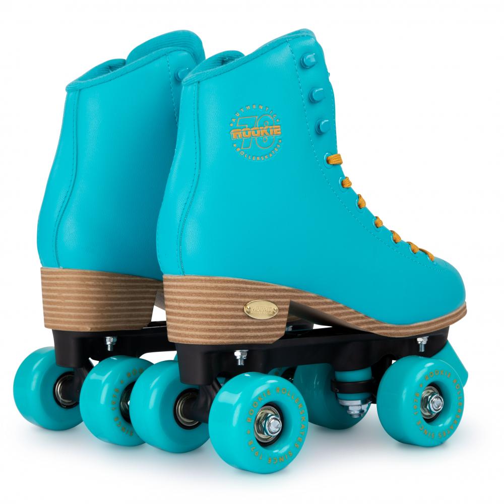 A pair of vibrant blue Rookie Classic 78 Quad Roller Skates comes with orange laces and wooden soles. These vegan-friendly skates showcase matching blue wheels, a black chassis, and feature the circular Rookie brand logo on the side of the boot.