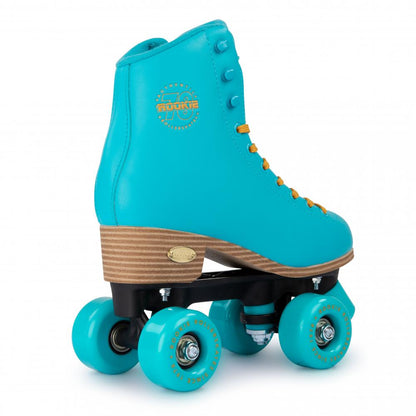 The Rookie Classic 78 Quad Roller Skates - Blue by Rookie feature a vibrant blue boot with turquoise wheels, a wooden heel, and yellow laces. Made from vegan-friendly materials for sustainability, the notable brand logo is prominently displayed on the side of the boot.