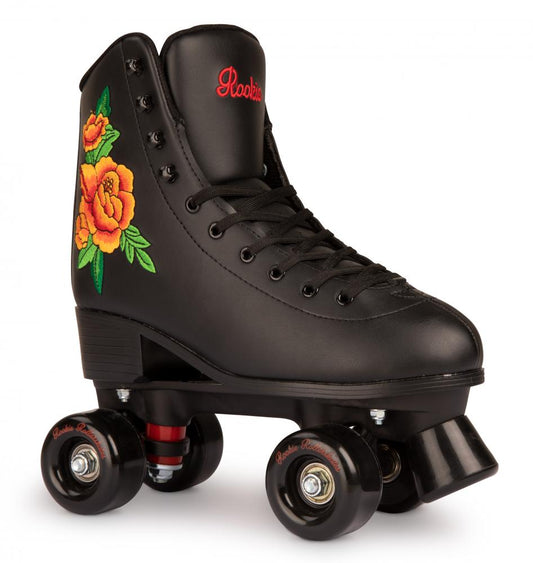 The Rookie Rosa Quad Roller Skate, available in black, is decorated with vibrant yellow and orange floral embroidery. It features black wheels and a toe stopper, complemented by red branding text on the tongue. This vegan-friendly skate includes a padded fleece lining for added comfort.