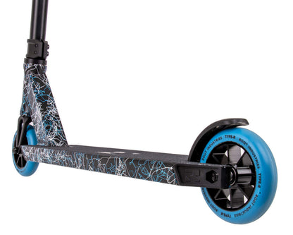 A close-up of the deck and front wheel of a Root Industries Type R Complete Stunt Scooter in black, blue, and white. The deck displays a white abstract pattern, and the wheels are blue with black cores, highlighting an elegant Type R design.