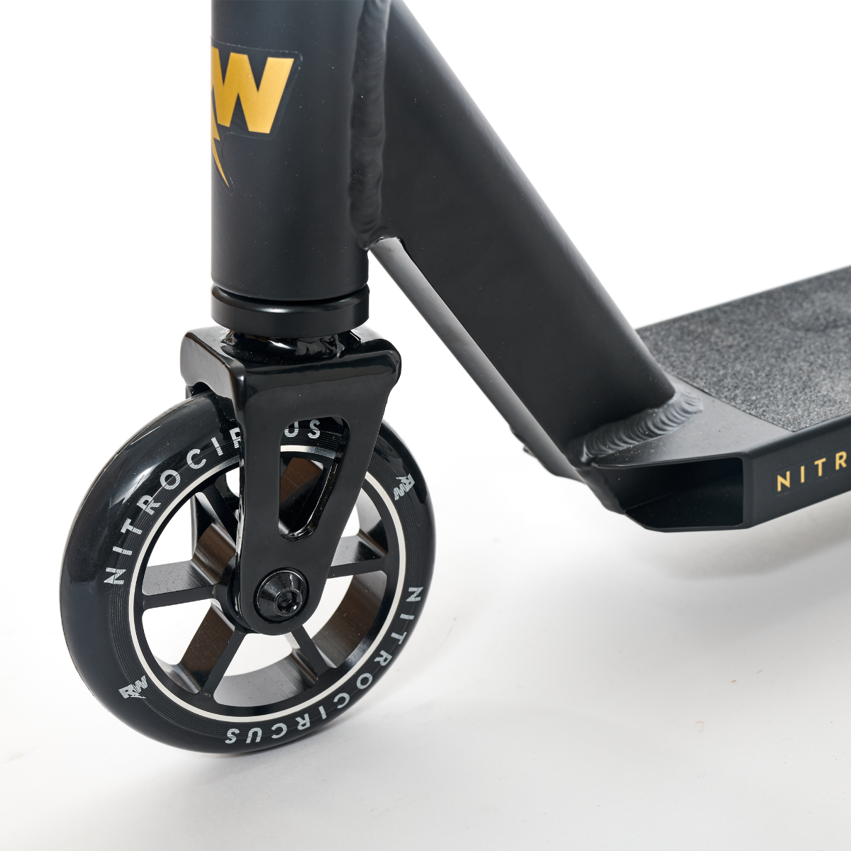 Close-up of the front wheel of the Nitro Circus Ryan Williams Signature Replica 2022 Complete Stunt Scooter in Black, highlighting its metallic core. This scooter boasts a textured footplate and visible handlebar, all designed to deliver an extreme ride.