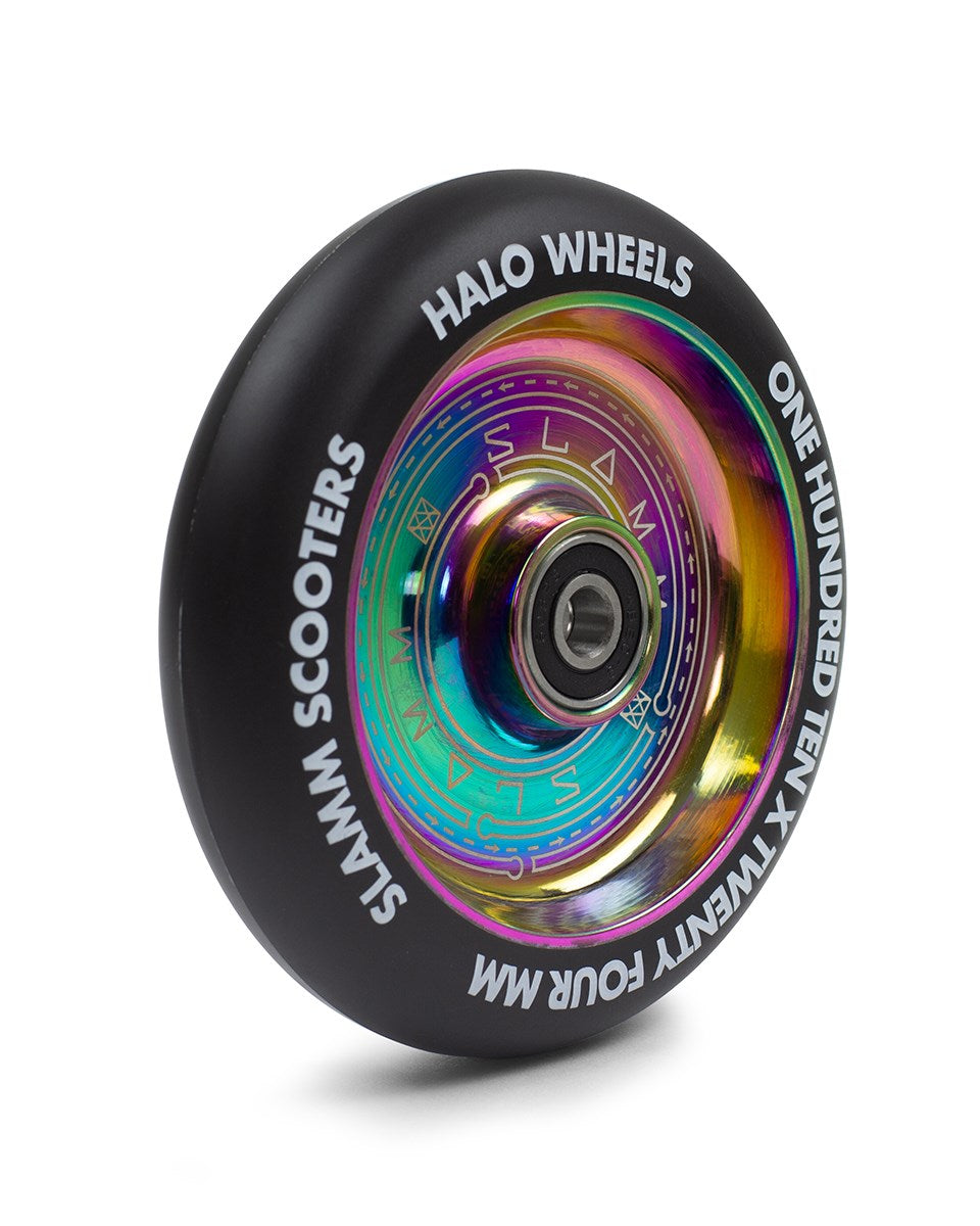 Close-up of a black stunt scooter wheel with a shiny, neochrome core. The text on the wheel reads "Slamm," "Halo Wheels," and "One Hundred Ten x Twenty Four MM." Featuring 88A urethane for durability and ABEC-9 bearings for smooth performance from the Slamm Halo Deep Dish 110mm Stunt Scooter Wheel - Neochrome.