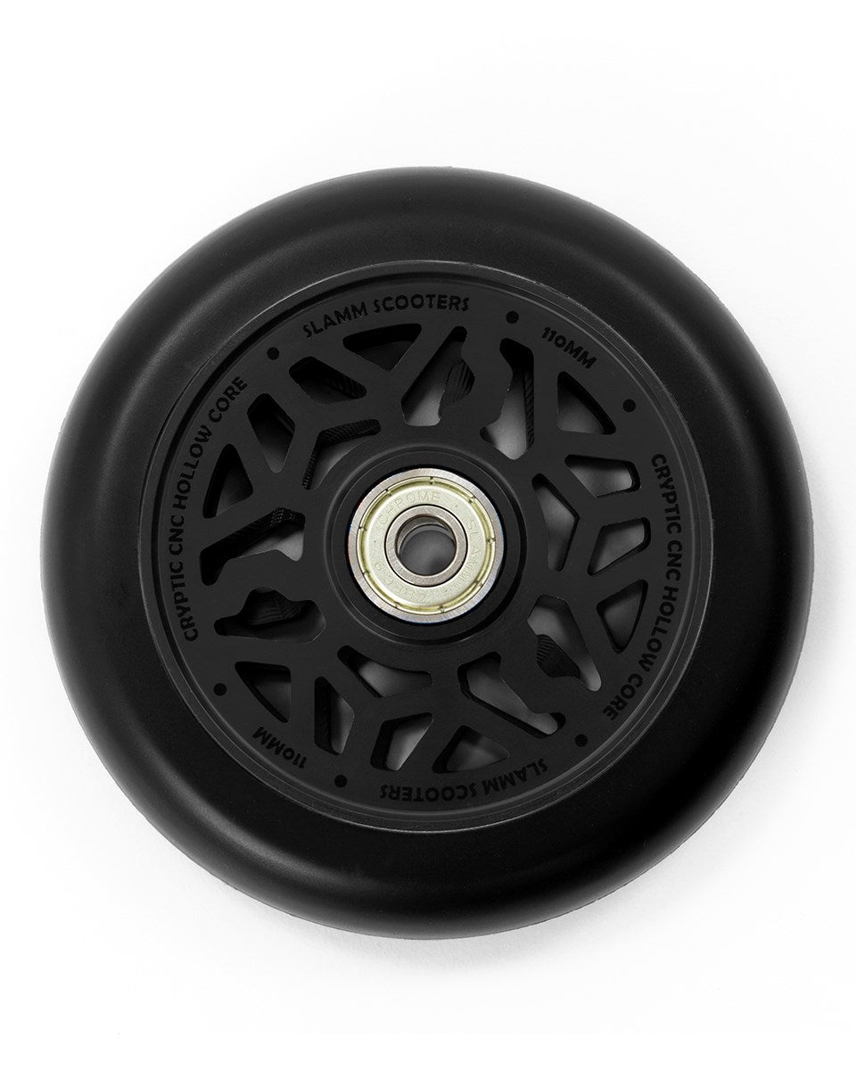 The Slamm Cryptic 110mm Stunt Scooter Wheel in black showcases an intricate, hollow-core design with the text "Cryptic CNC Hollow Core" and "Slamm Cryptic 110mm Wheels." A central ABEC-9 chrome bearing is visible, nestled within a durable black tire made from Super High Rebound Mi-T Urethane.