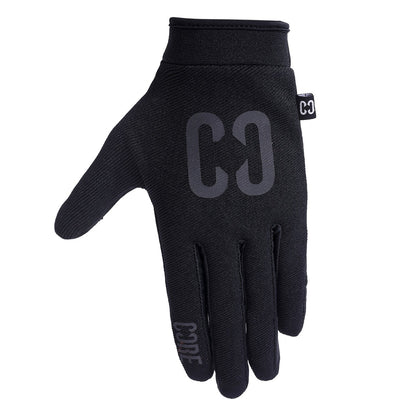 The CORE Aero Skate Protection Gloves in Stealth Black are sleek gloves that feature "CODE" on the index finger and "CØ" on the back. Made from smooth, fitted material, they boast a grip-enhancing design ideal for riding enthusiasts. They also include a small tag on the side and are touch screen friendly for convenient device use.