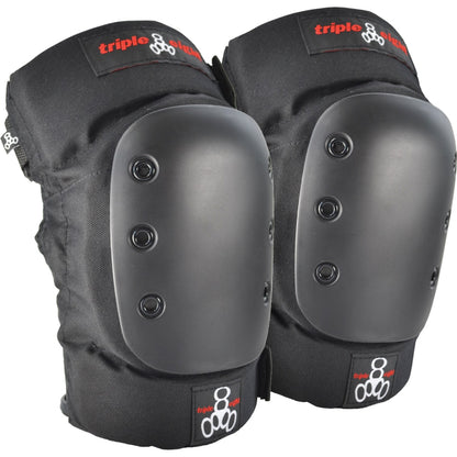 The "Triple 8 Park" protection set, featuring black knee pads with hard plastic caps adorned with visible rivets, displays the red and white "Triple 8" logo on the fabric. They incorporate EVA memory foam to provide comfort during intense sport sessions.