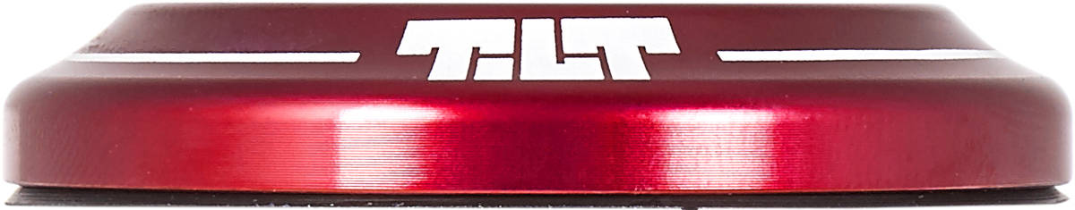 Close-up of a Tilt Integrated Stunt Scooter Headset in metallic red with a rounded edge, featuring the Tilt brand name in bold white letters on the side. The surface is shiny and reflective, showcasing anodized dust covers that enhance its minimalist design.