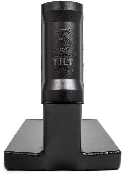 A sleek black metal device stands vertically on a rectangular base, mirroring the design of the Tilt Theory V3 Pro Black Stunt Scooter Deck - 5.5" x 22", with engraved text and a logo displaying "Designed by TILT 5.5.32.6" on its cylindrical section.