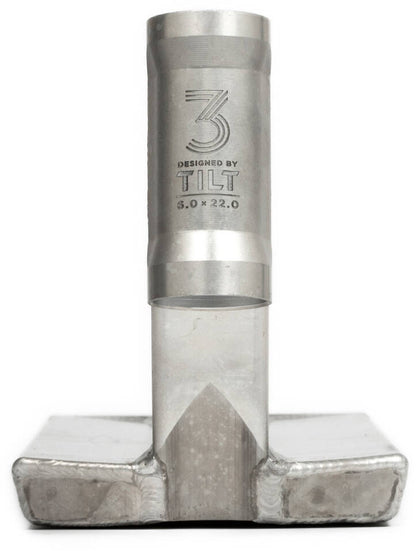 Close-up of a metallic scooter part with a cylindrical shaft and rectangular base, ideal for slides and grinds. The 3rd generation version boasts intricate engravings such as the number 3 and "DESIGNED BY TILT 6.0 x 22.0." Its surface presents a textured, industrial look, perfectly suited for the Tilt Theory V3 Selects Raw Chrome Silver Stunt Scooter Deck measuring 6" x 22".