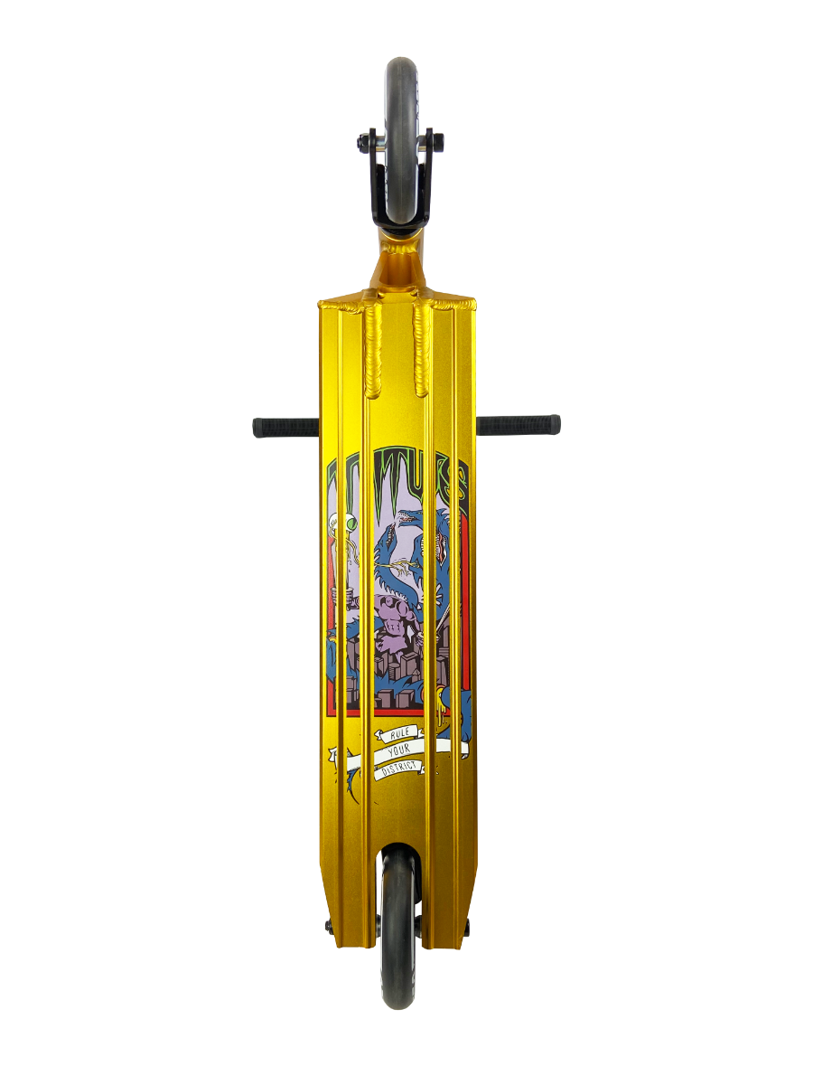 The District Titus Complete Stunt Scooter by District features high-quality components, showcasing a gold deck with vertical metal bars and a vibrant illustration of a character with a hammer. Tailored for beginner riders, it includes black handlebars and wheels, along with detailed text and designs.