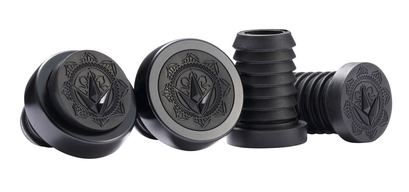 Four black rubber table leg caps are displayed. On the left, three are angled together, showcasing a geometric pattern similar to high-quality hand grips. The cap on the right stands upright, highlighting its accordion-like expandable section, which echoes the precise design associated with a Blunt Envy collaboration.