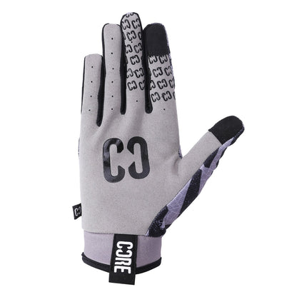 The CORE Aero Skate Protection Gloves in Zag Grey feature a sleek design with black accents and "CO" on the back. These gloves include a touch screen friendly index finger embellished with a pattern of small "C" shapes. A durable black wrist strap prominently displaying the CORE brand name enhances both style and functionality, while strategically placed ventilation holes provide breathability.