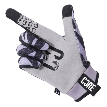 The CORE Aero Skate Protection Gloves in Zag Grey, featuring black and white patterns and a "CORE" logo on the wrist, display a gesture with the index finger and thumb extended. These riding gloves are designed to be touch screen friendly for your convenience.